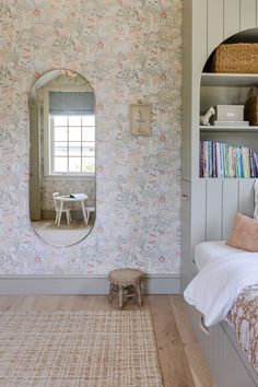 a room with a bed, book shelf and mirror on the wall next to it