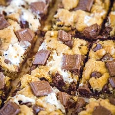 chocolate chip cookie bars with marshmallows on top are cut into squares and stacked together