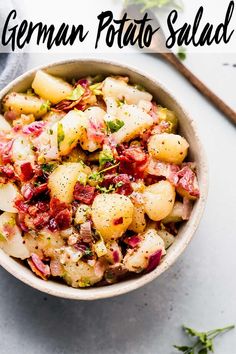 a bowl filled with potatoes and bacon on top of a table