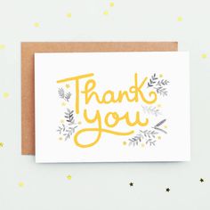 a thank card with the words thank you written in gold and silver on top of it