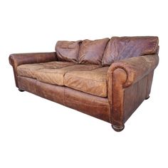 a brown leather couch sitting on top of a white floor