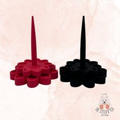 two black and one red candlesticks on a pink background