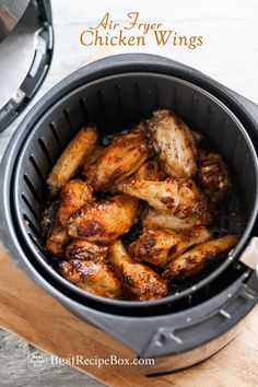 air fryer chicken wings in an air fryer with the words air fryer wings above it