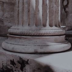 an old photo of a stone column in the middle of a building with snow on it