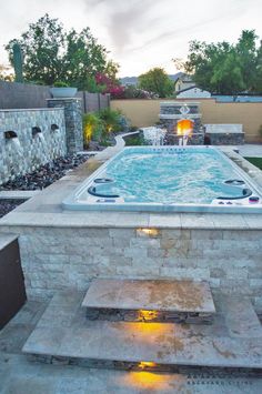 an outdoor hot tub in the middle of a backyard