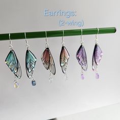 six butterfly wings hanging from a green hook on a white background with the words earings 2 - wing