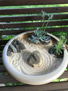 a planter with rocks and succulents in it