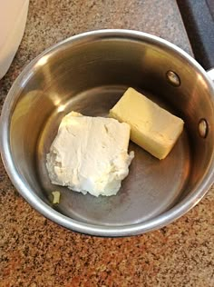 two cubes of butter in a metal bowl on a counter next to a blender