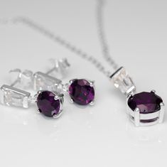 "Handmade Purple Amethyst & Simulated Diamond 925 Sterling Silver Earrings and Pendant set Material: Solid 925 Sterling Silver Stamped: 925 Pendant Stone: Round Brilliant Cut Purple Amethyst Number of stones: 1 Measurement: 9mm Secondary Stone: Baguette Cut Simulated Diamond Number of stones: 1 Measurement: 5mm x 4mm Chain: 18\" Sterling Silver Earrings Stone: Round Brilliant Cut Purple Amethyst Number of stones: 2 Measurement: 7mm Secondary Stone: Baguette Cut Simulated Diamond Number of stones: 2 Measurement: 5mm x 4mm Can be purchased seperately or as a set, please add both items to basket if you are wanting a set. These come beautifully presented in a gift box and gift bag" Earrings Stone, Jeweled Earrings, Jewellery Gift, Sterling Silver Necklace Pendants, Amethyst Pendant, Baguette Cut, 925 Sterling Silver Earrings, Sparkle Diamonds, Necklace Earring Set