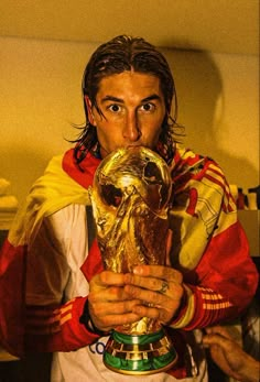 a man holding a soccer trophy in his hands