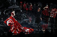 a group of mannequins dressed in red, black and white outfits on stage