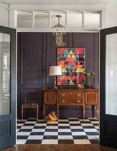 a room with a checkered floor and painting on the wall