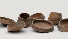 several wooden bowls and spoons on a white background