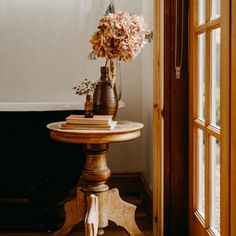 a vase filled with flowers sitting on top of a table next to a bath tub