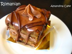 a piece of cake with chocolate icing and nuts on top sitting on a plate