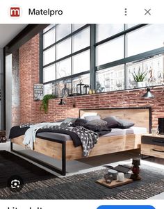 a bed room with a neatly made bed next to a window and a brick wall