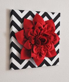 a black and white chevroned wall with a red flower on the top of it