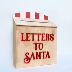 a wooden box with the words letters to santa written on it and a red striped top