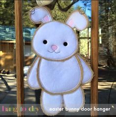 an easter bunny door hanger hanging from a wooden frame