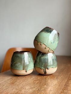 two green vases sitting on top of a wooden table