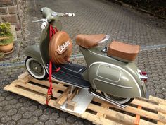 a scooter is sitting on a wooden pallet