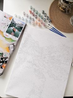 an open book sitting on top of a table next to some crafting supplies and scissors