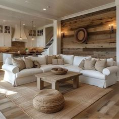 a living room with white couches and wooden walls in the background is an open floor plan