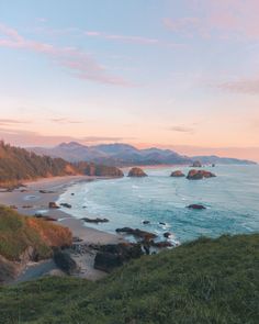 the beach is surrounded by mountains and water