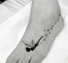 a black and white photo of a person's foot with a butterfly on it