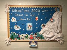 a bulletin board with penguins and snowflakes on it in a school hallway that says, sliding into 2020 with jesus in our hearts