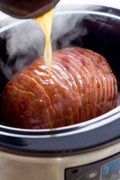 a slow cooker filled with cooked meat being poured into it