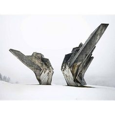 two large rocks are standing in the snow