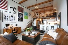 a living room filled with lots of furniture next to a stair case in front of an american flag