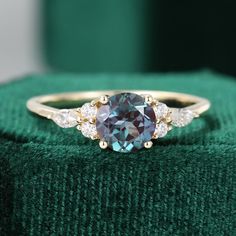 a blue diamond ring sitting on top of a green cloth