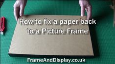 a person holding a piece of cardboard with the words how to fix a paper back to a picture frame