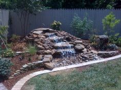 a small waterfall in the middle of a garden