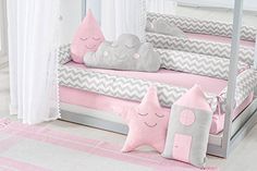 a child's day bed with pink and grey pillows