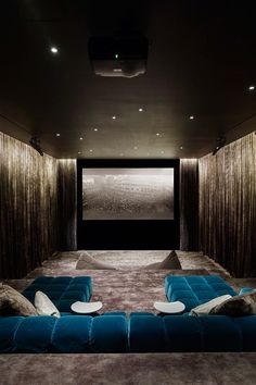 an empty theater room with blue couches