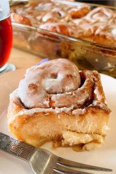 a piece of cinnamon roll sitting on top of a white plate next to a fork