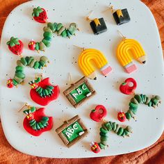 some very cute earrings on a white plate with red and green decorations around them,