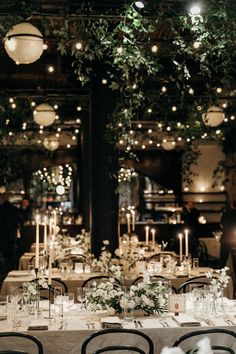 the tables are set with candles and centerpieces for an elegant wedding reception at night