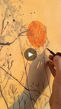 someone is drawing on the wall with paint and pencils in front of an orange ball