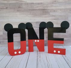 the word one is made out of wood and has mickey mouse ears on each side