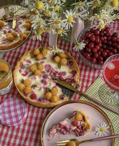 a table topped with pies covered in toppings next to glasses of juice and flowers