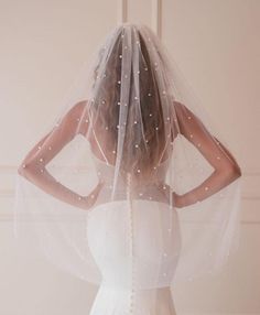 the back of a bride's veil with pearls on it