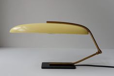 a yellow desk lamp sitting on top of a table