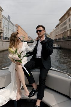 a man and woman sitting on the back of a boat