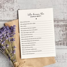 a bouquet of lavender flowers sitting on top of a piece of paper next to a note