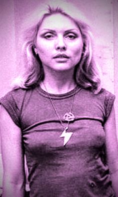 a woman standing in front of a wall with a lightning bolt on it's chest