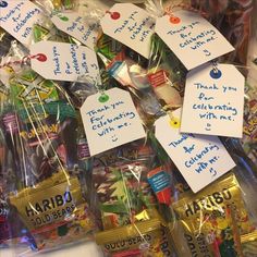 some candy wrapped in plastic bags with handwritten notes attached to the top of them